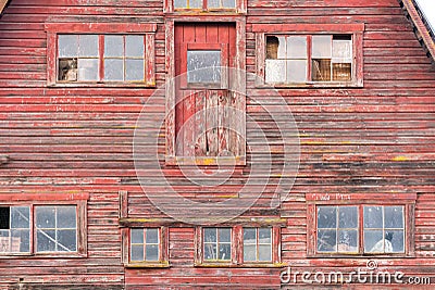 Old red barn with red broken window. Stock Photo