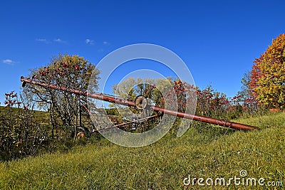 An old tube elevator on a hillside of autumn colored trees Stock Photo