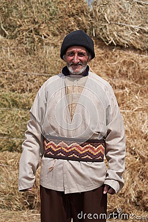 Old farmer man with Hay bales on background. Elderly muslim farmer Stock Photo