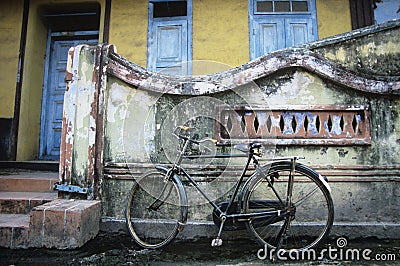 Old fashioned bicycle left by crumbling wall Stock Photo
