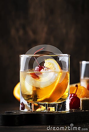 Old Fashioned - classic alcoholic cocktail with bourbon whiskey, bitter, cane sugar and ice in retro glasses on vintage bar Stock Photo