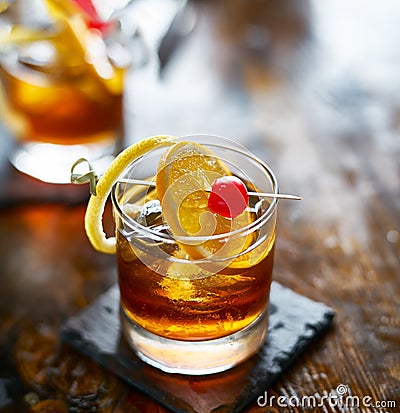 Old fashioned cocktail garnished with cherry, orange and lemon peel Stock Photo