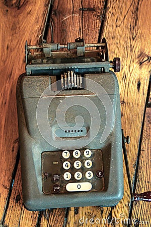 Old fashioned green adding machine on wood slat table Stock Photo