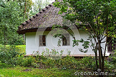 Old fashioned house with a thick thatched roof in Ukraine Stock Photo