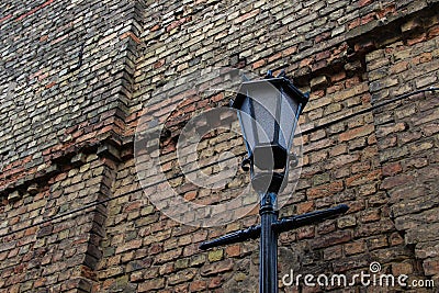 Old-fashioned street lantern in front of the old brick wall Stock Photo