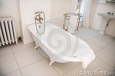 Old fashioned style bathroom with white bathtub. Stock Photo