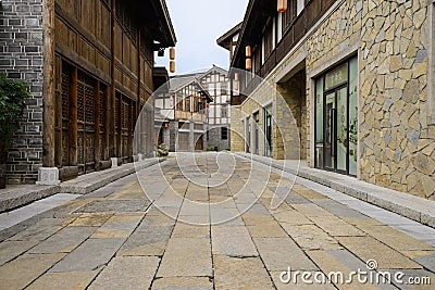 Old-fashioned tile-roofed buildings along flagstone street Editorial Stock Photo