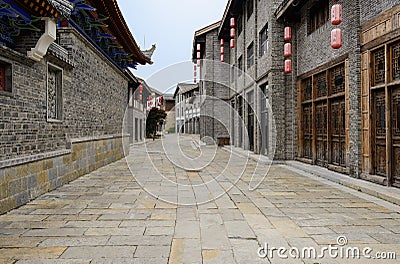 Old-fashioned tile-roofed buildings by stone street Editorial Stock Photo