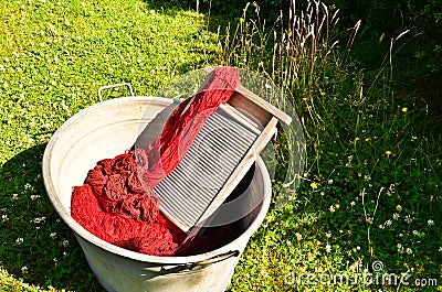 An old fashioned washing trougth filled with dyed and washed strings and ropes of red wool Stock Photo