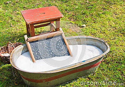An old fashioned washing trougth a vintage child chair, and wooden vessels to bring water Stock Photo