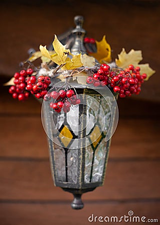 Vintage handmade lantern with painting and garland of maple leaves and rowen berries Stock Photo
