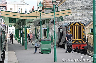 Old fasioned railway station with tourists, guard and train Editorial Stock Photo