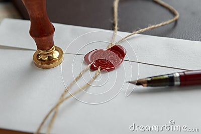 Old feather, envelope and sealing wax on wooden table Stock Photo