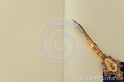 Old feather pen and empty sheet of paper. Back drop background. View from above Stock Photo