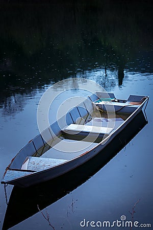 Old fisherman boat on the lake at night Stock Photo