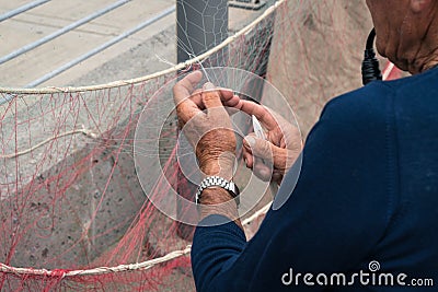 Fisherman reparing fishing net Stock Photo