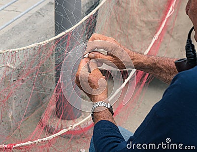 Senior fisherman reparing fishing net Stock Photo