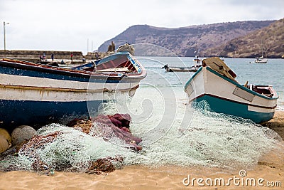 Old fishing boat on the shore. Boat with nets waiting for fishermen on the beach of Cape Verde Editorial Stock Photo