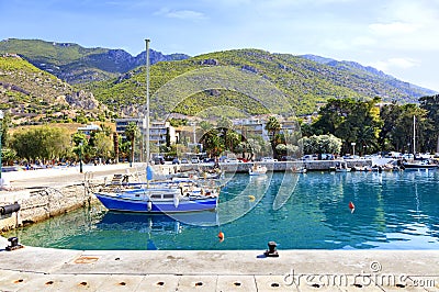 View of the pier of the bay, where old fishing schooners, boats and boats are moored in the clear waters of the Ionian Sea Stock Photo