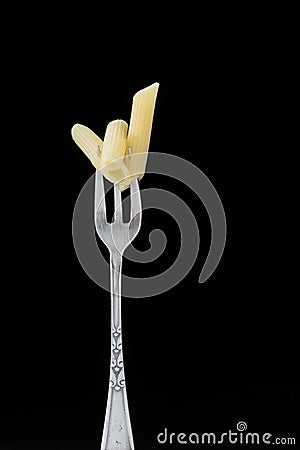 Old fork with penne pasta Stock Photo