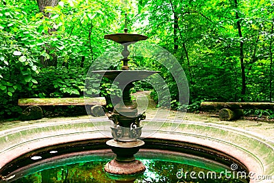 Old fountain in a green park Stock Photo