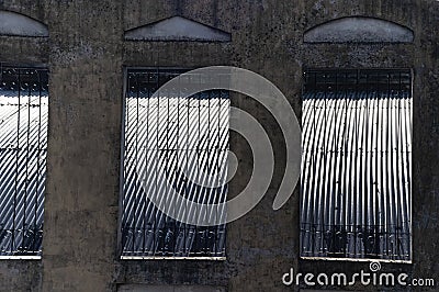 Old front with hole and faded worn out walls grating with rust Stock Photo