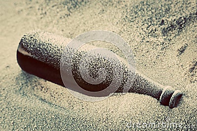 Old frozen bottle lost on the beach. Stock Photo