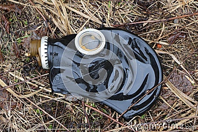 Old gas mask lies on the wilted grass after the rain. concept: biological and gas danger, the end of the world, Apocalypse, death Stock Photo