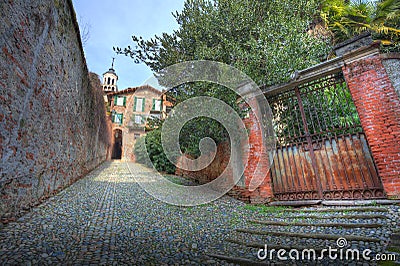 Old gate and narrow paved street in Saluzzo. Stock Photo