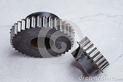Old gear worn out, chipped gears on cement background. Concept of engineering spare part Stock Photo
