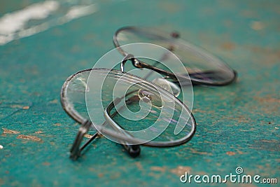 Old glasses and damaged lenses are placed on the green table tennis table. Stock Photo