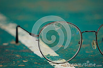 Old glasses and damaged lenses are placed on the green table tennis table. Stock Photo