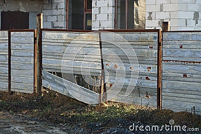 Old gray gate with broken iron and brown rust Stock Photo