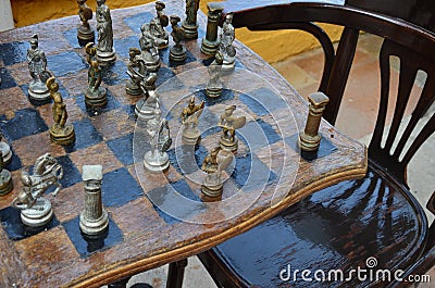 Old Greek chess figures on an antique chessboard Stock Photo