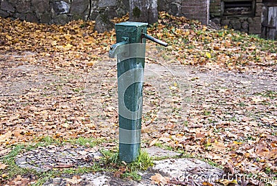 Old green antic water pomp Stock Photo