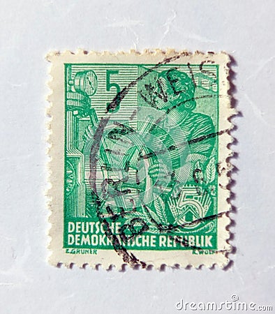 An old green east german postage stamp with a design of a female boat captain Editorial Stock Photo