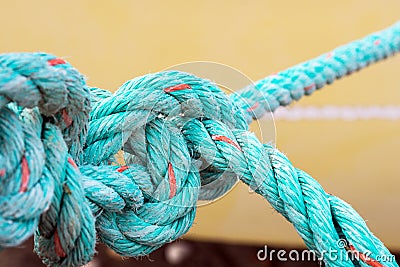 Old green rope knotted on a yellow background. Knot. Insoluble problem concept Stock Photo