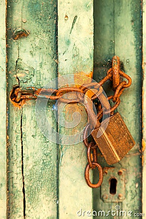 Old green rural door with rusty padlock Stock Photo