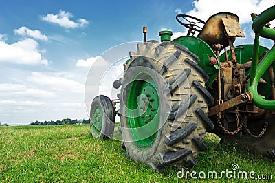 Old green tractor in the field Stock Photo