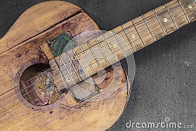 Old guitar on concrete wall background with blurred front and back background with bokeh effect Stock Photo