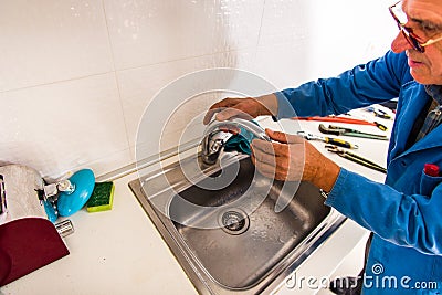 Old handyman working in the kitchen Stock Photo