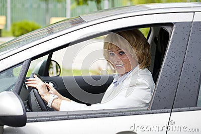 Old happy elderly driver woman 55-60 years in jacket Driving a C Stock Photo