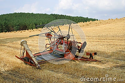 Old hay rake reaper-binder - rustic, oldfashioned farm equipment, used for field works during harvest season. Stock Photo