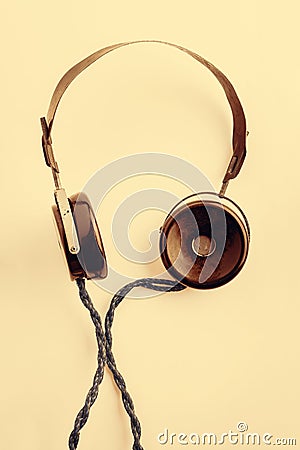 Old headphones with a long wire. Yellow toning vintage radio headphones on a light background. The concept of ancient radio Stock Photo