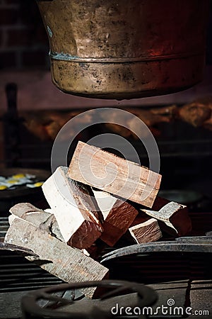 Old hearth with pile of fire wood and pot. Indoor. Stock Photo