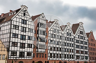 Row of medieval granary houses on Granary Island, Gdansk, Poland. Reconstructed storehouse buildings with moody cloud sky Stock Photo