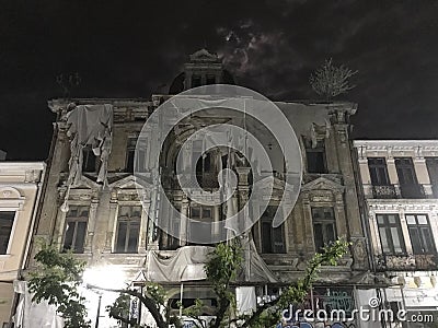 Old spooky ruin hotel in the night and a spooky tree in front Stock Photo