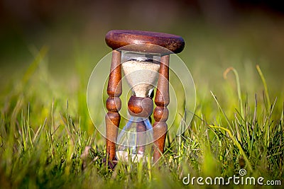 Old hourglass among green grass Stock Photo