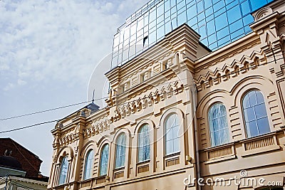 an old house against the background of a modern glass multi-storey building. Editorial Stock Photo