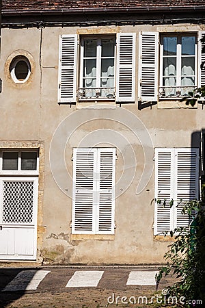 Old house facade with shutter and white door Stock Photo